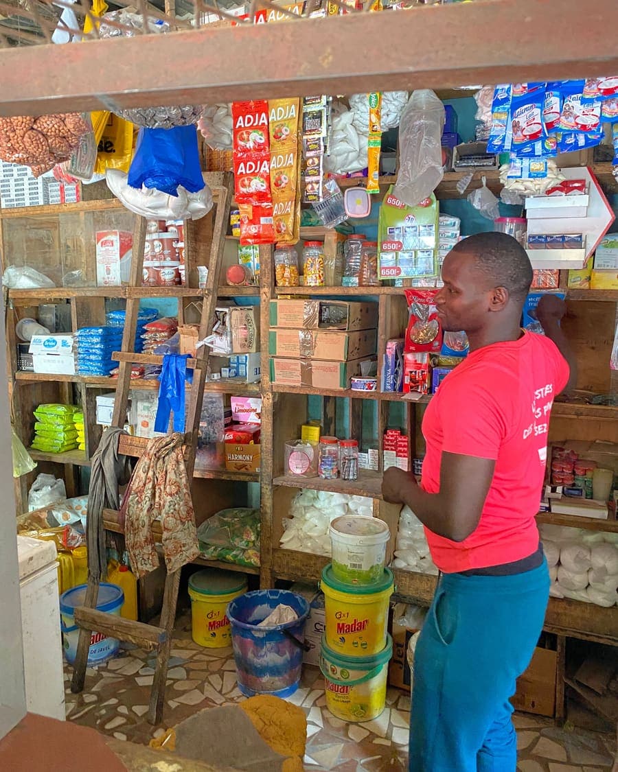 Un boutiquier range les produits sur les étagères de sa boutique